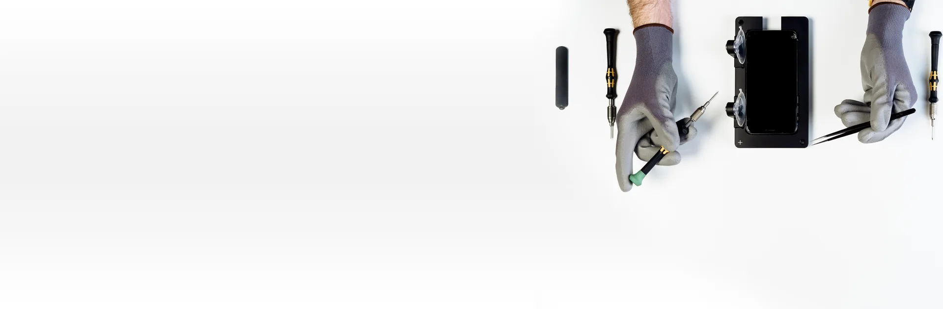 Tecnico smartLab con guanti antistatici durante la riparazione di uno smartphone, con cacciaviti di precisione e pinzette
