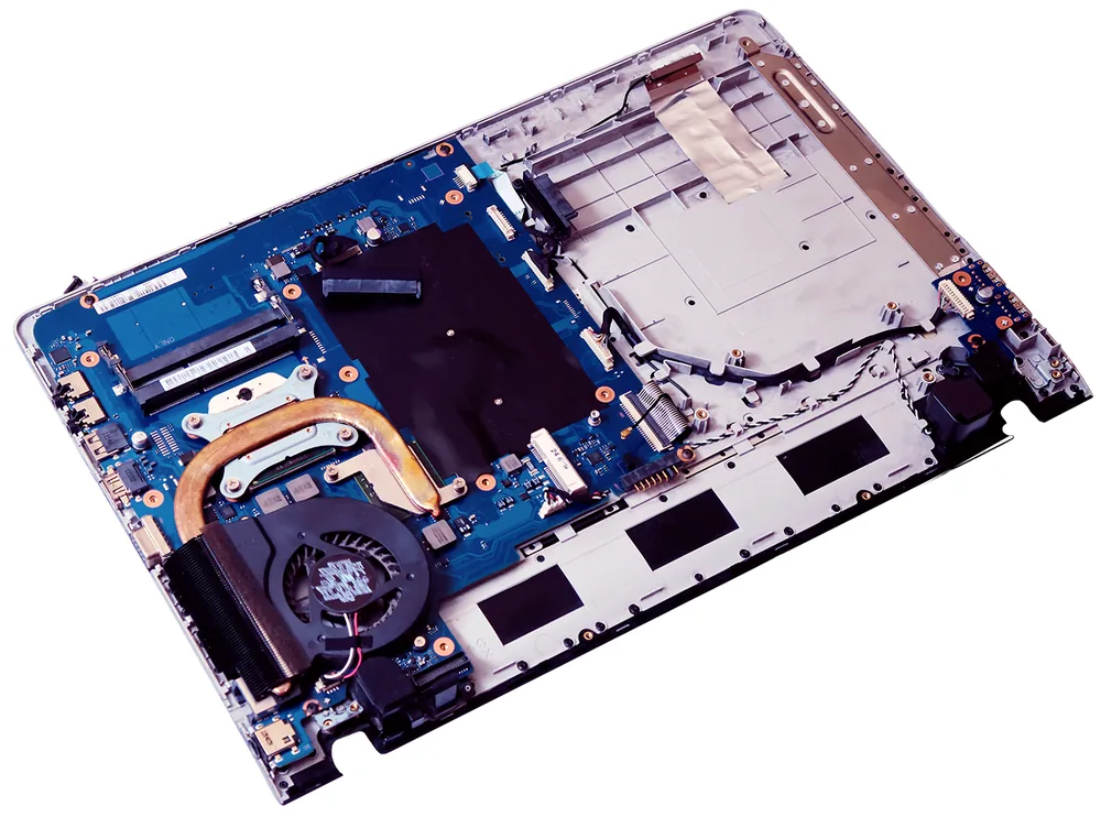 Computer portatile smontato con scheda madre, ventola e dissipatore in vista durante una riparazione hardware